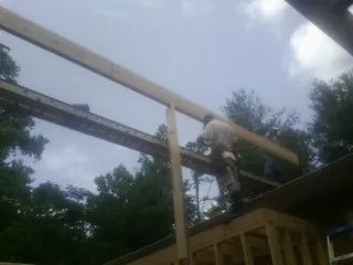 Carpenter setting a ridge beam over a new addition frame — Ice Dam Removal by Roofing Brothers in Ellsworth
